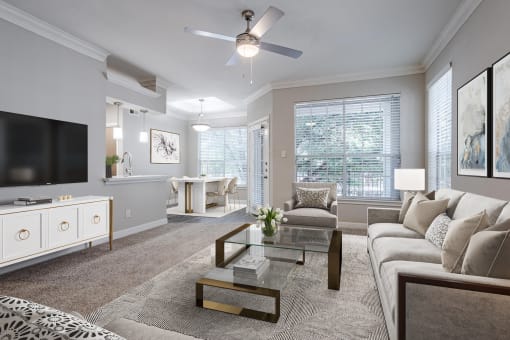 Houston Apartments – Gramercy Park – living room with large windows, ceiling fan, and a view of the dining room