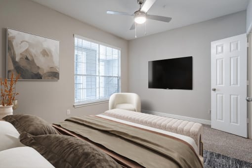 Pet-Friendly Apartments in Houston, TX – Gramercy Park – a bedroom with a bed and a ceiling fan
