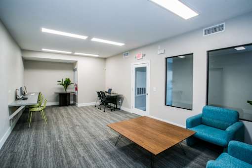 A room with a table, chairs, and a plant.