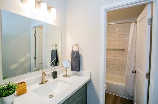Apartment bathroom with vanity and tub-shower combination at Haven at Lone Mountain in northwest Las Vegas