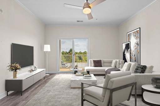 Spacious living room at Hawks Landing Apartments in Hickory, NC with gray sofa, white coffee table, and TV on cabinet