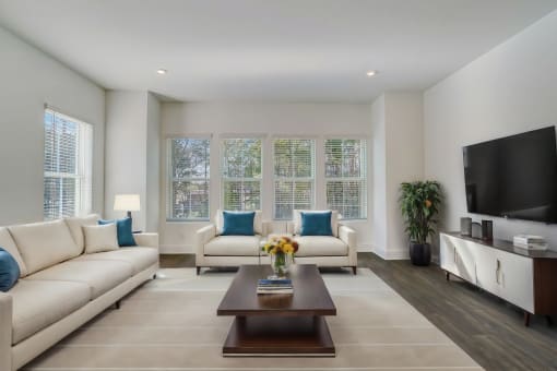 Pet-Friendly Townhomes in Avondale Estates, GA – Henley Avondale – living room with white couches and a coffee table, hardwood floors and large windows