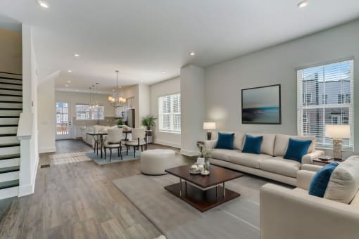 Luxury Four Bedroom Townhomes in Avondale Estates, GA - Henley Avondale – living room with a couch and a table and hardwood floors