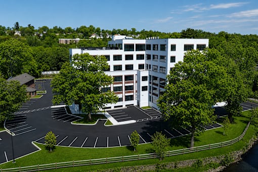A white building with a parking lot in front of it.