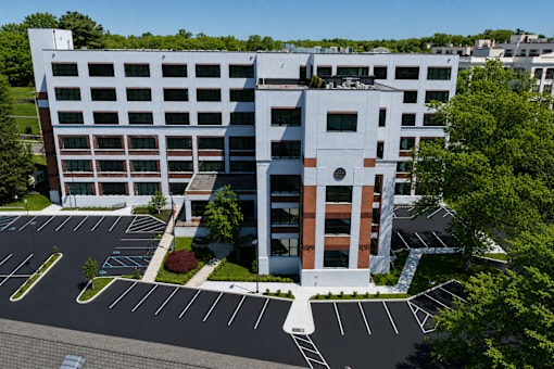 A modern building with a parking lot in front.