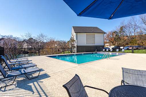 Pet-Friendly Apartments in Antioch, TN– Hickory Lake – A pool area with sun loungers and a building in the background.