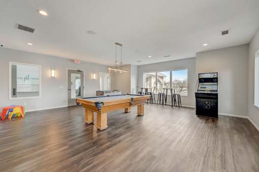 Community game room with pool table and open seating at Hinton Heights Apartments in Cottage Grove, MN, a pet-friendly apartment community with spacious shared amenities.