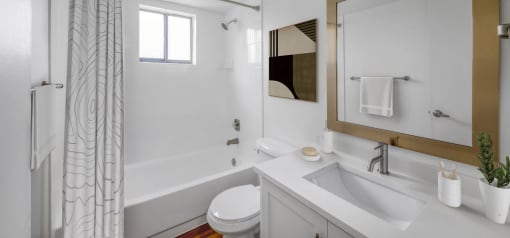 Horizons North Apartments near Ojus, Fl photo of a bathroom with a white sink and toilet and a white bathtub