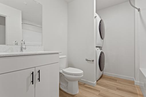 A white bathroom with a toilet and a washing machine.