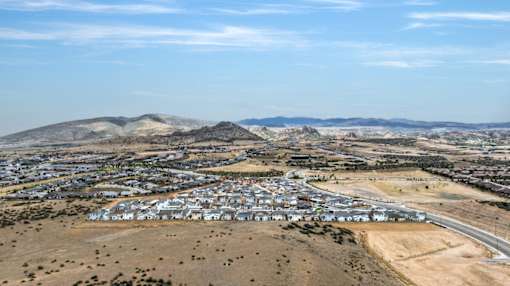A small town with a lot of houses and a mountain in the background.