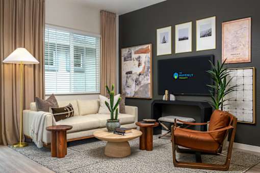 A living room with a white sofa, a brown leather chair, and a wooden coffee table.
