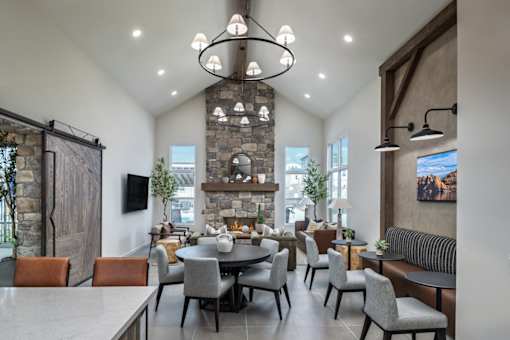 A modern dining room with a stone fireplace and a large table set for a meal.