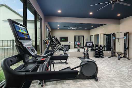 A gym with treadmills, exercise bikes, and other equipment.