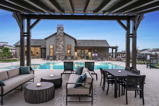 A modern outdoor living space with a pool and furniture.