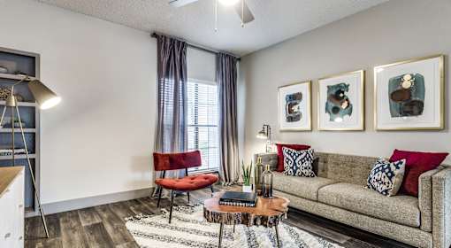 A living room with a couch, chair, and pictures on the wall.