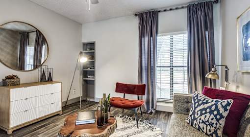 A living room with a red chair and a grey couch.