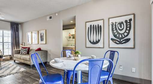 A dining room with a white table and blue chairs.