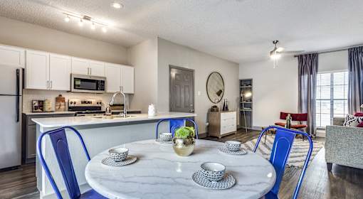 A modern kitchen with a dining table set for two.