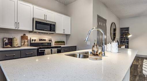 A kitchen with a white countertop and a sink.