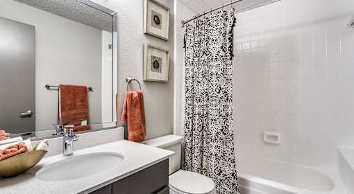 A bathroom with a white sink and a shower curtain.