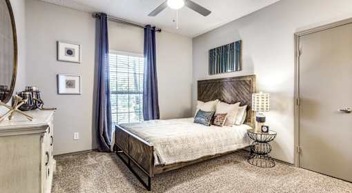 A bedroom with a bed, dresser, and mirror.