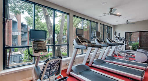 A gym with treadmills and exercise bikes is shown.
