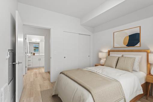 A bedroom with a bed, nightstand, and a painting on the wall.