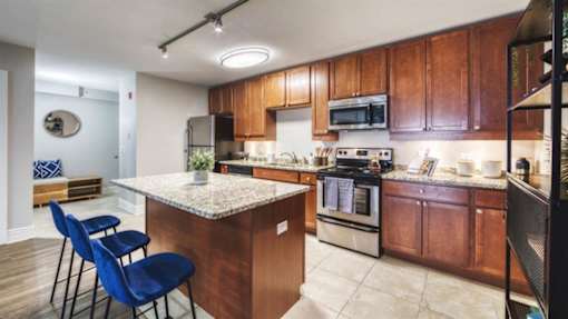 A kitchen with wooden cabinets and a granite countertop.