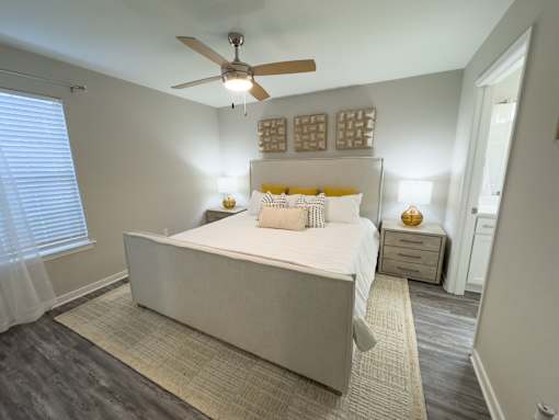 Twin Oaks Apartments in Hattiesburg Mississippi A bedroom with a large bed and a ceiling fan.