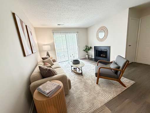 A living room with a couch, chair, and fireplace.