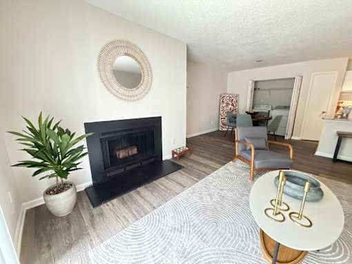 A living room with a fireplace and a plant.