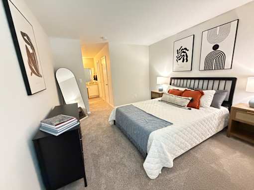 A bedroom with a large bed and a mirror on the wall.