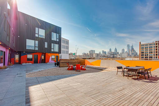 A modern building with a wooden deck and orange accents.