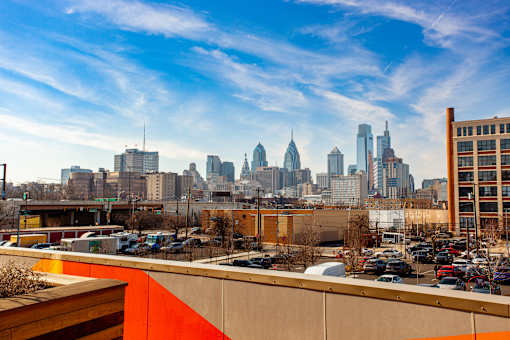 A city skyline is visible in the distance behind a parking lot.