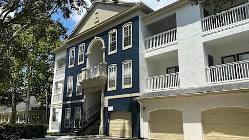 A blue and white building with a balcony and a staircase.