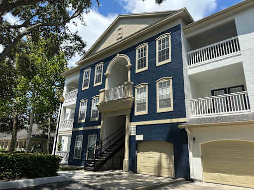 A blue and white building with a balcony and a staircase.