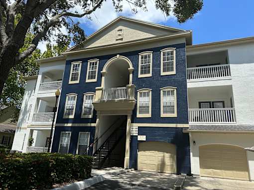 A blue and white two-story apartment building with a garage door.