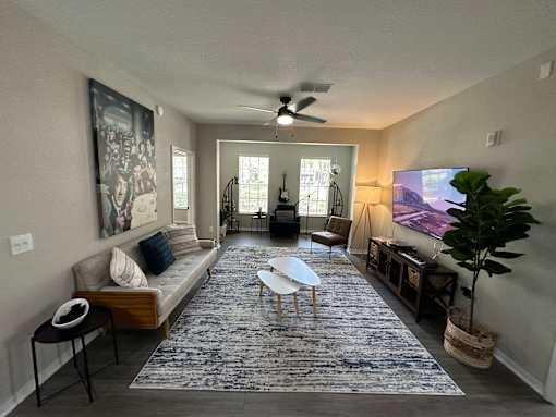 A living room with a couch, a chair, a table, and a rug.