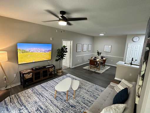 A living room with a flat screen TV mounted on the wall.