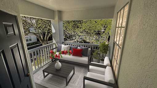 A balcony with a table and chairs overlooking a garden.