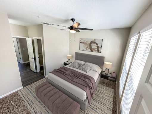 A bedroom with a bed, a ceiling fan, and a rug.