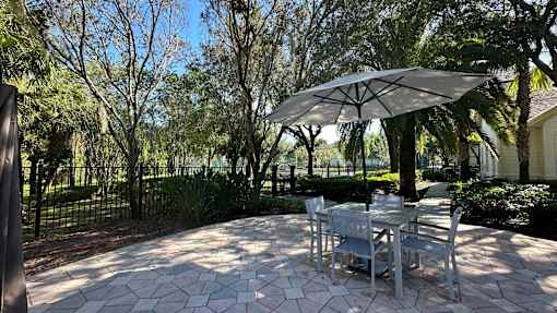 A patio with a table and chairs under an umbrella.