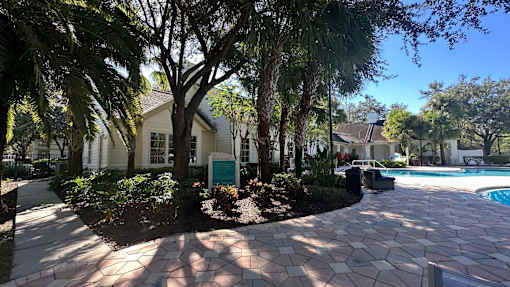 A house with a pool and a tree in front.