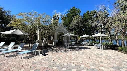 A patio with a gazebo surrounded by trees.