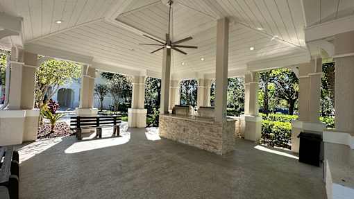A covered patio with a ceiling fan and a stone pillar.