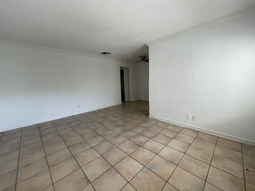 the living room and dining room of an empty house with tile flooring