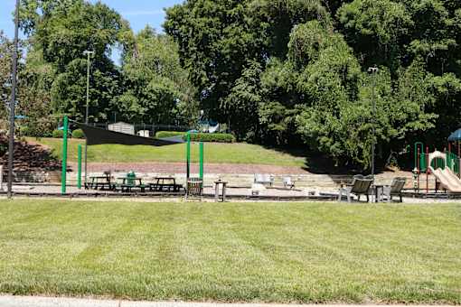 A park with a playground and picnic tables.