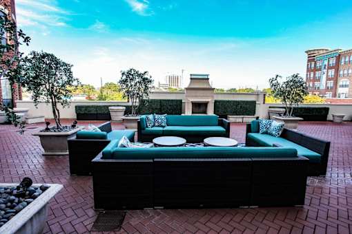 A patio with a black couch and a table with plates on it.