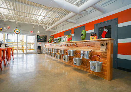 A long wooden table with metal buckets on it.
