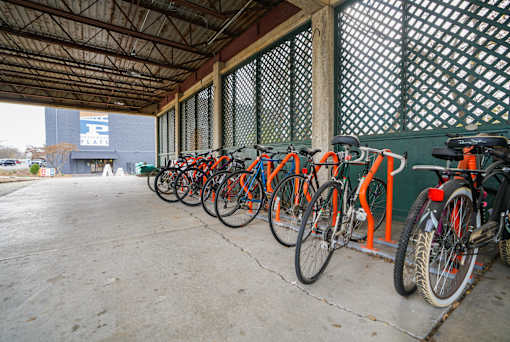 A row of bicycles are parked in a bike rack.